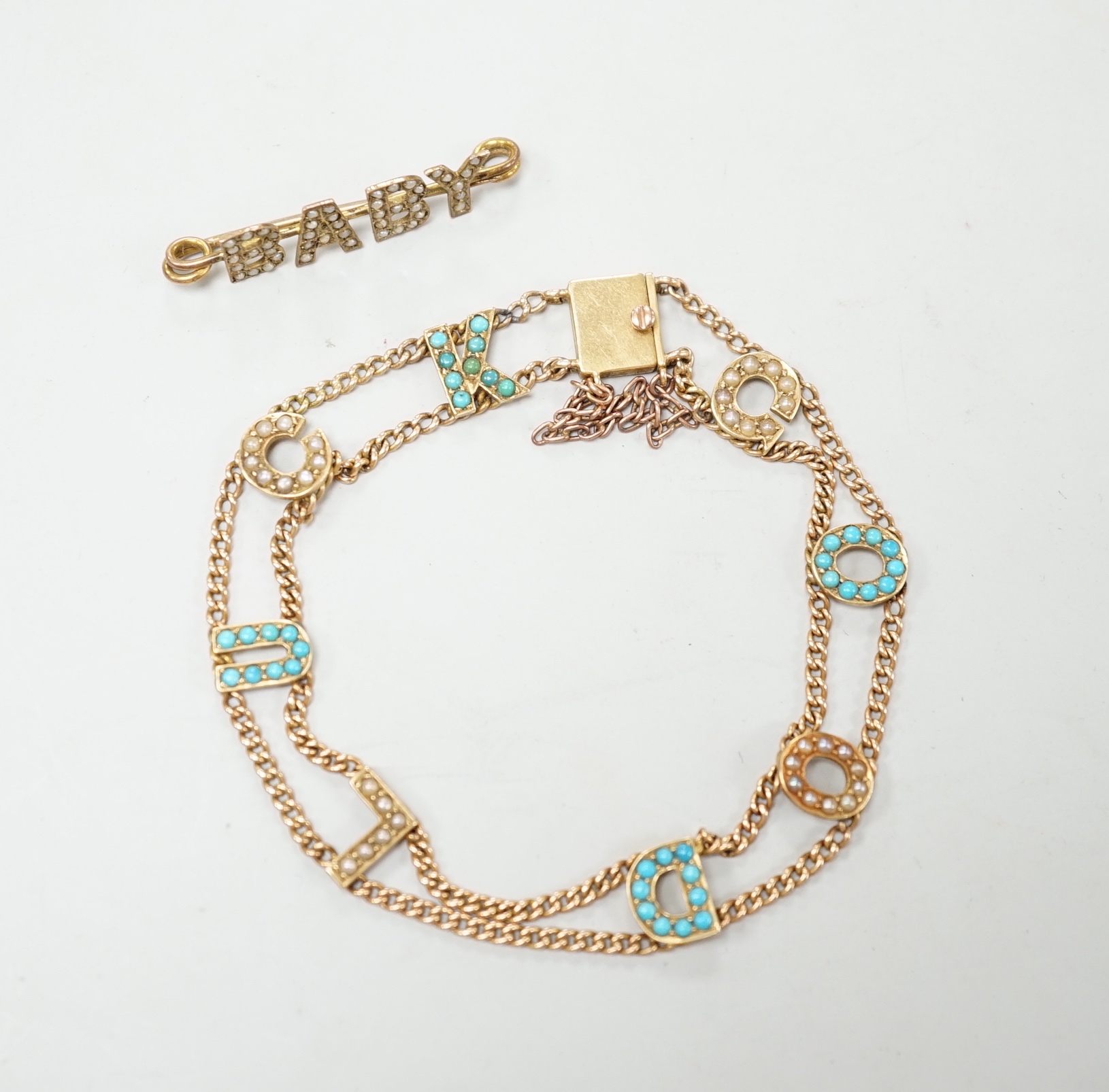 An Edwardian 15ct?, turquoise and seed pearl set 'Good Luck' chain bracelet, 17cm and a yellow metal and seed pearl set 'Baby' bar brooch.